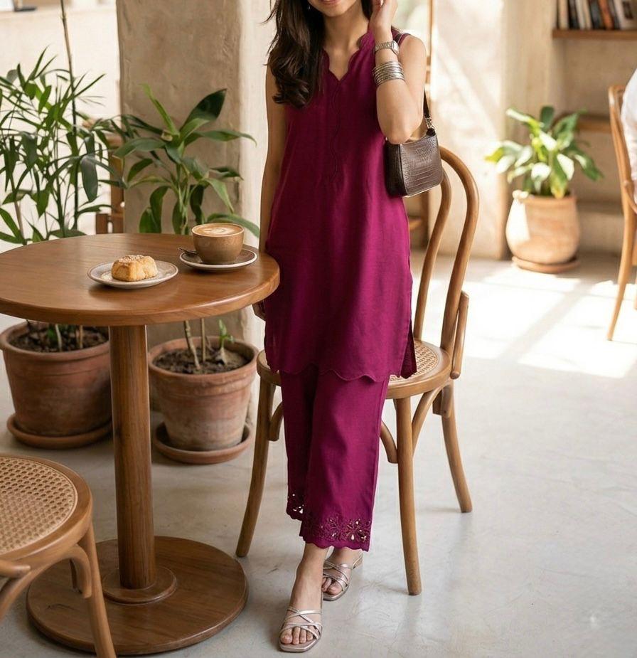 Woman in a purple outfit standing in a cozy cafe with wooden furniture and plants.