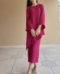 Woman wearing a magenta dress standing on a tiled floor with a beige wall in the background